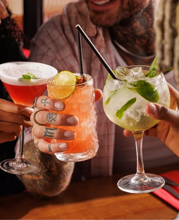 Three friends holding cocktails