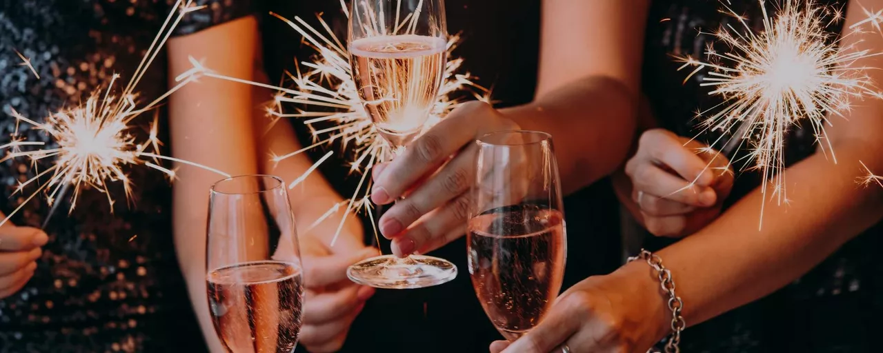 Hands holding drinks and sparklers