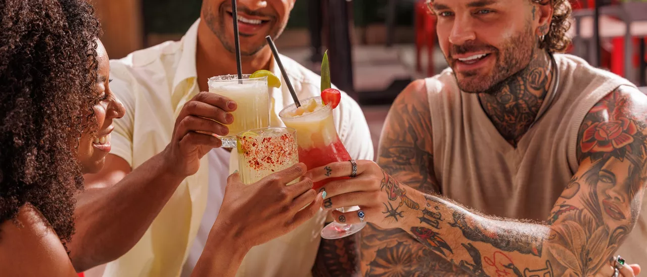Three friends celebrating with cocktails