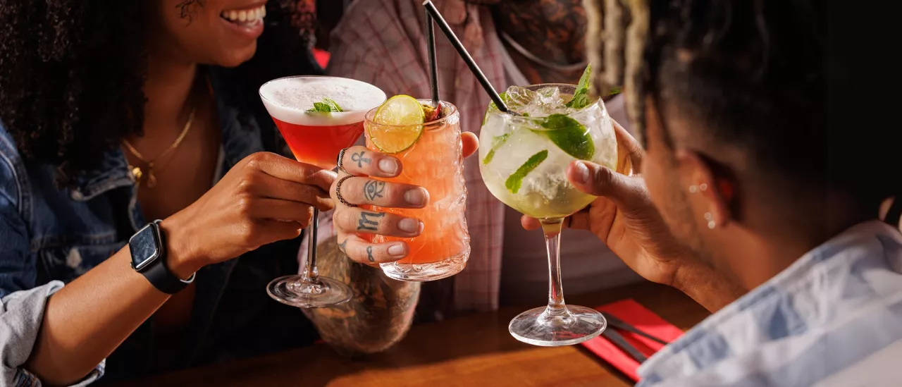 Three friends holding cocktails