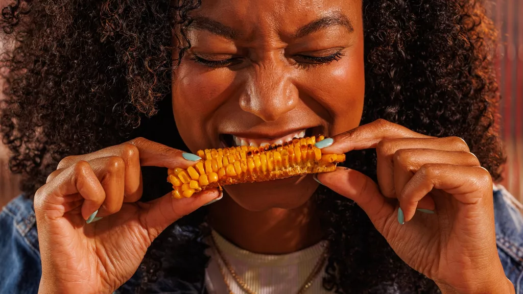 Woman biting into corn