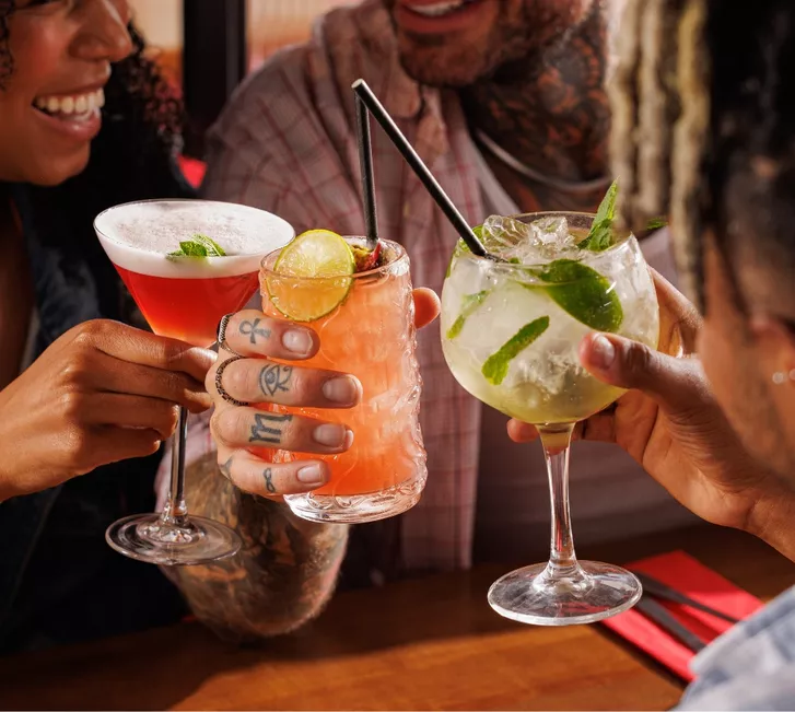 Three friends holding cocktails